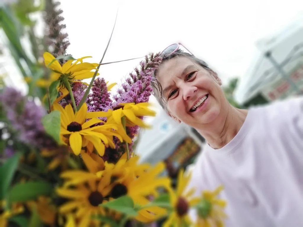 Rene standing next to flowers.